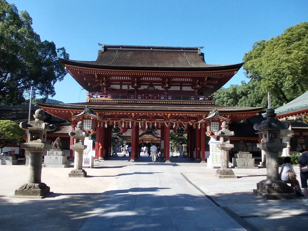 The vermilion two-story gate and stone lanterns of Dazaifu Tenmangu Shrine