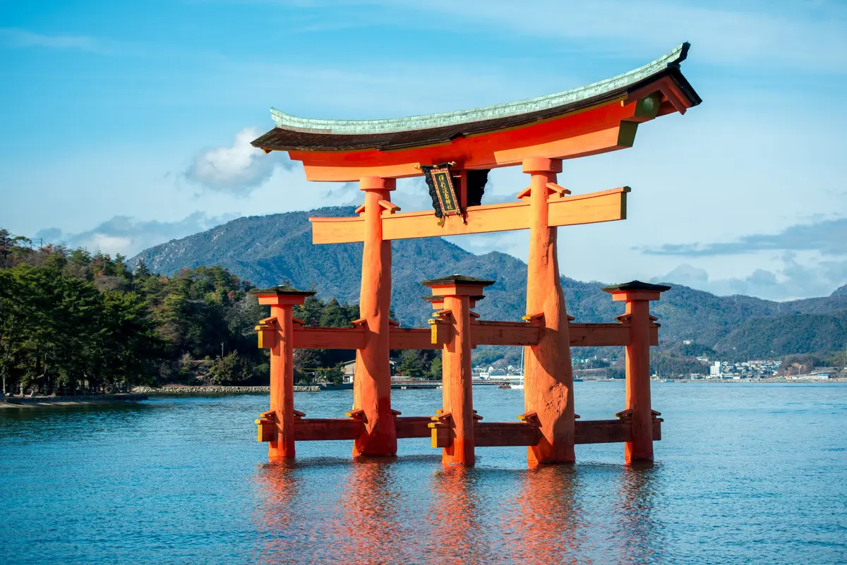 青空與群山襯托下矗立海中的嚴島神社大鳥居