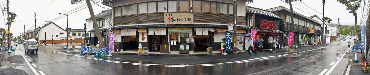 A rainy street in front of Izumo Taisha with a matchmaking shop and a zenzai sign