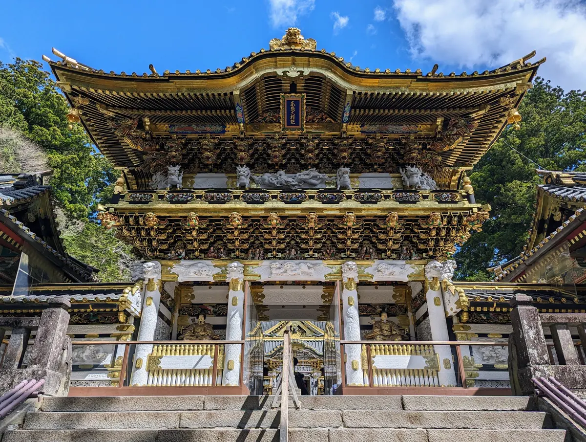 矗立在藍天下、金白裝飾華麗的陽明門