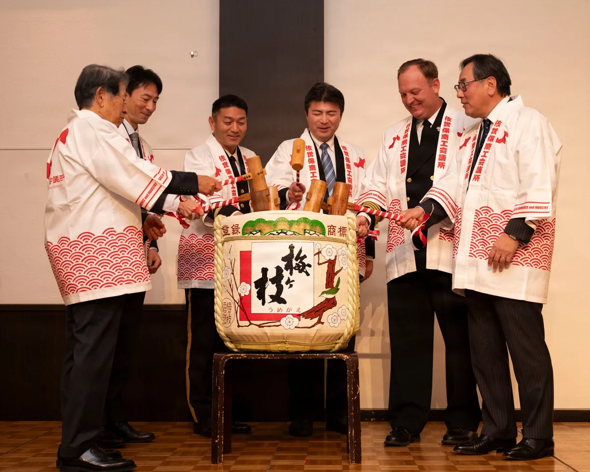 People breaking open a sake barrel lid with wooden mallets in a kagami-biraki ceremony