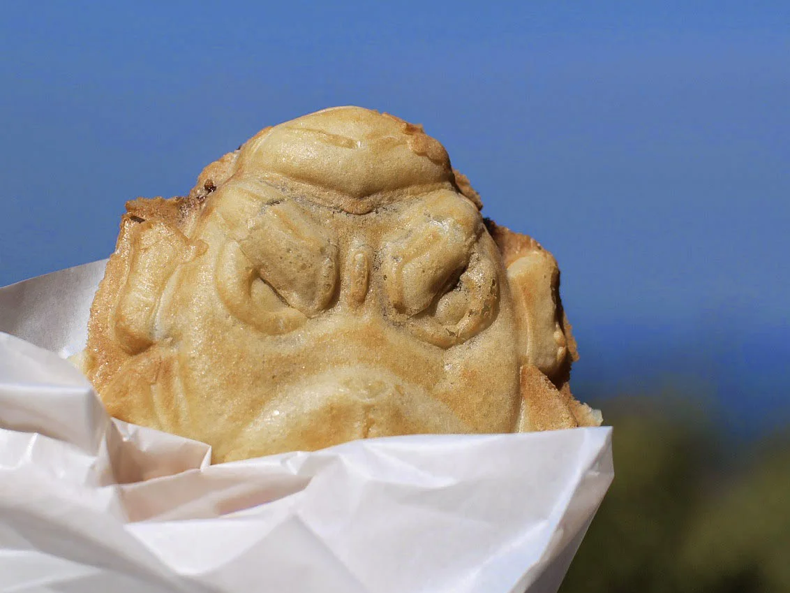 紙に包まれた、天狗の顔の形の焼き菓子
