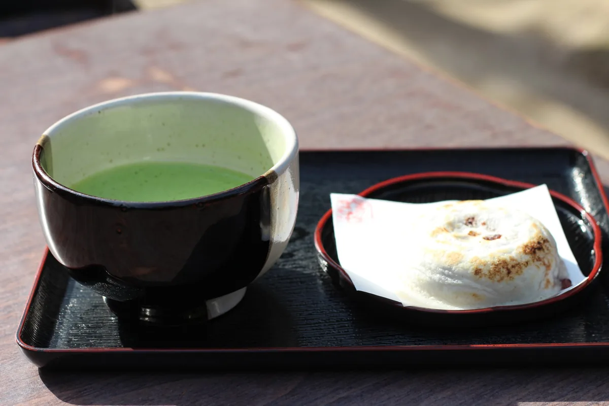 Umegae mochi served with matcha on a black lacquer tray